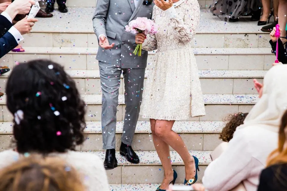 Invitados lanzando confeti a los novios en una escalinata